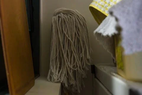 Mop head hangs vertically, resting against wall Stock Photos