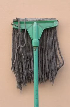 A mop lying against a wall. Foto stock
