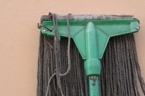 A mop lying against a wall. Foto stock