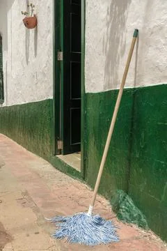 A mop sun drying on a tiled sidewalk Foto stock