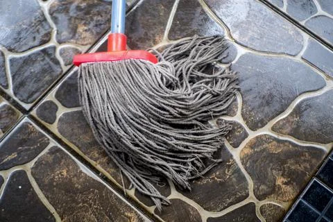 Mop on textured tile floor Stock Photos