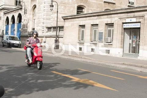 Moped Driver in the Street of Paris Stock Photos
