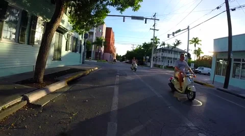Mopeds and scooters driving down street in key west florida keys Stock Footage 41869070