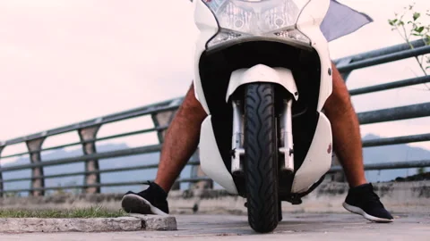 The mopeds front wheel rolls toward the camera. Video stock 313733376