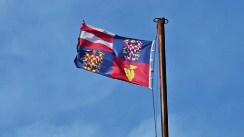 A Moravian regional flag with an eagle and grape emblem waves on a metal Stock Footage 342279749