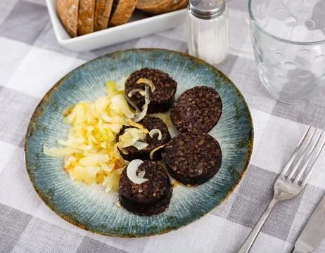 Morcilla con cebolla - fried blood sausage with onion on table Stock Photos