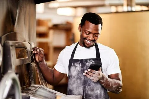 More positive feedback on my page. a male baker using his cellphone while Stock Photos
