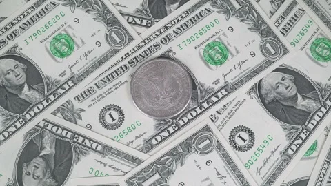 Morgan Silver Dollar Against US One Dollar Bills. Stock-Footage 320289371