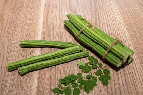 Moringa Oleifera or drumstick vegetable with leaves on wooden background Foto stock