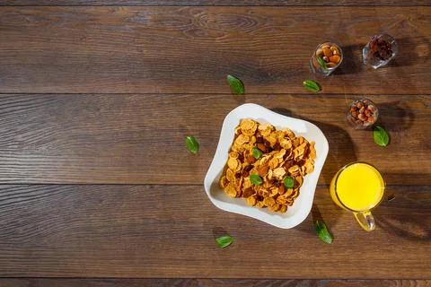 Morning breakfast, corn flakes, raisins, almonds, orange juice, top view, on  Stock Photos