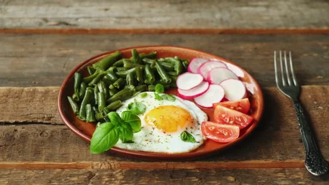 Morning breakfast. Fried egg, fresh tomatoes slices, radish and basil leave.. Stock Footage 340333066