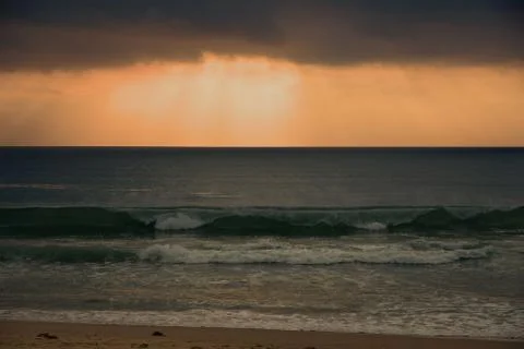 Morning cloudscape over breaking waves Stock Photos