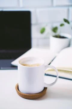 Morning coffee is on the table next to the computer. Stock Photos