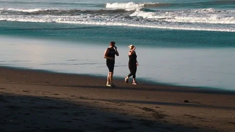 Morning couple walks across the beach Stock Footage