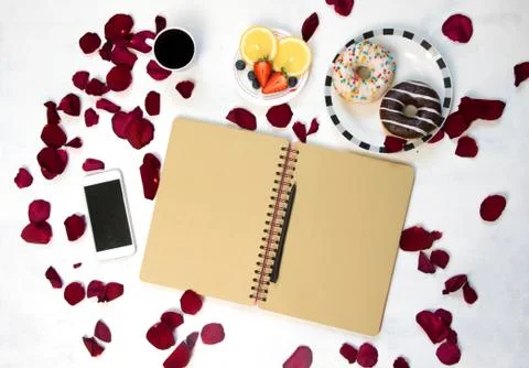 Morning Cup of coffee, empty notebook and roses flowers, fruits and donuts on Stock Photos