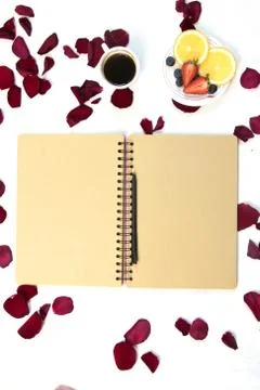 Morning Cup of coffee, empty notebook and roses flowers, fruits and donuts on Stock Photos