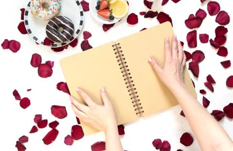 Morning Cup of coffee, empty notebook and roses flowers, fruits and donuts on Stock Photos