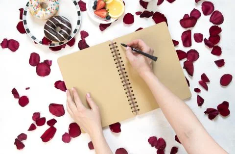 Morning Cup of coffee, empty notebook and roses flowers, fruits and donuts on Stock Photos