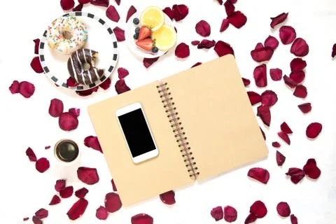 Morning Cup of coffee, empty notebook and roses flowers, fruits and donuts on Stock Photos