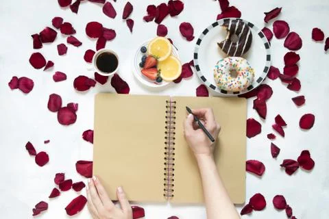 Morning Cup of coffee, empty notebook and roses flowers, fruits and donuts on Stock Photos