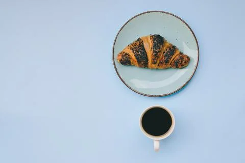 Morning with cups of hot black coffee and sweet croissant on blue background Stock Photos