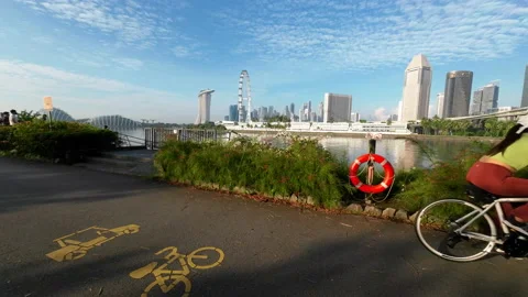 Morning dolly forward cyclists facing city blue sky Stock Footage 165593145