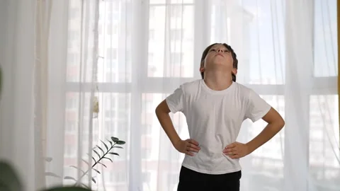 Morning exercise program that the child does. The boy plays sports at home. A Stock Footage 276379272