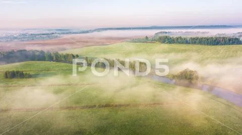Morning fog over river, meadow and forest. Nature sunlight scene Stock Photos