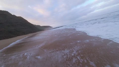 Morning light casts soft glow on beach waves Stock Footage 344673431