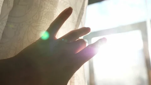 Morning light rays penetrate through curtains and hands. Young woman opening Stock Footage 151412359