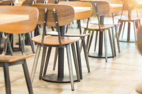 Morning light through rows of  Empty table and chairs in cafe restaurant Stock Photos