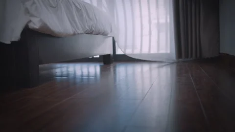 Morning light through the window and mens legs hanging off the bed Stock Footage 329661150