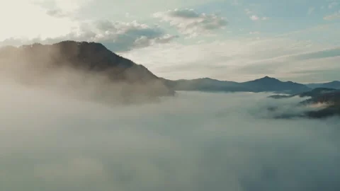Morning mist envelops mountain range at sunrise in serene landscape Stock Footage 289541506