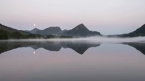 Morning moon set reflecting over the lake with clouds Stock Footage 122972053