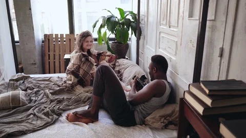 Morning photoshoot on the bed. Attractive woman in pajamas hides under the Stock Footage