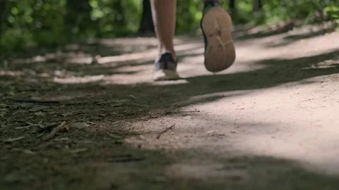 Morning run in the park, close-up of a man's sneakers as he runs away from the c Stock Footage 280186341