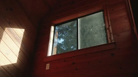 Morning sun streams through a rustic cabin window Stock Footage 327769377
