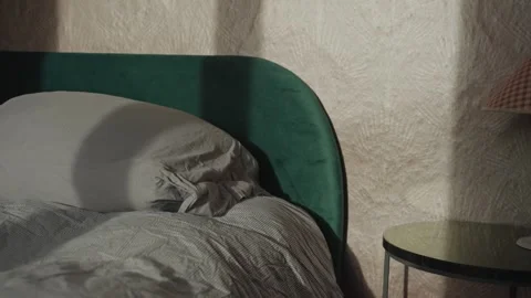 Morning sunlight and shadow shining on an unmade bed Stock Footage 339098001