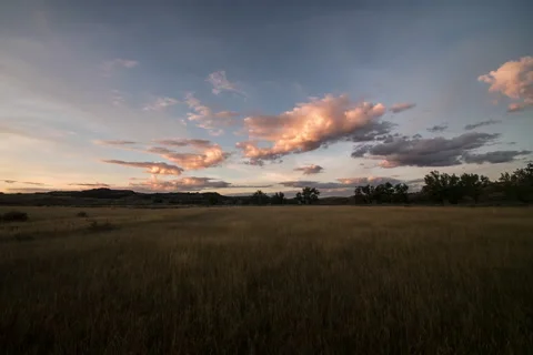Morning Time lapse of sunlight on clouds above Montana prairie in summer Stock Footage 61950058
