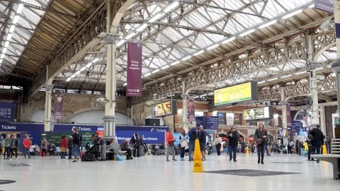 Morning travelers stroll through Victoria Station in London England Stock Footage