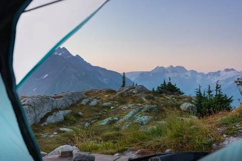 Morning view of mountain range from inside camping tent in nature. Stock Photos