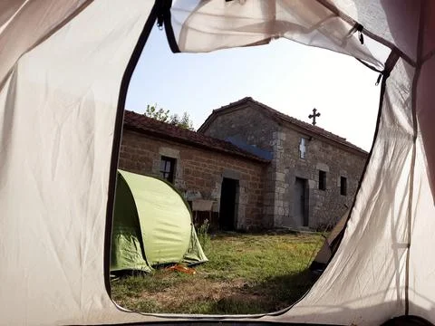 Morning view from a tent. Camping in front of a church. Stock Photos