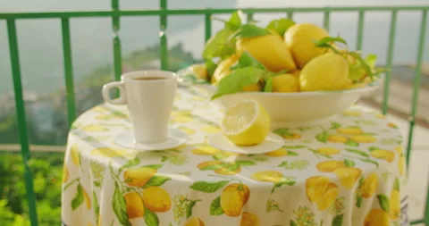 Morning's first cup of tea accompanies a fresh bowl of lemons on a balcony Stock Footage 274562277
