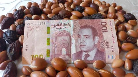 Moroccan 100 dirham banknote over Argan seeds Stock Photos