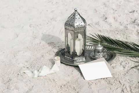 Moroccan, Arabic lantern with cup of tea, coffee and date palm leaf on silver Foto stock