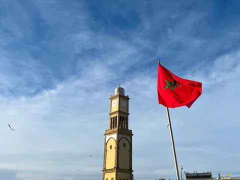 Moroccan Flag on Clock Tower Against Blue Sky in Casablanca Medina Stock Photos