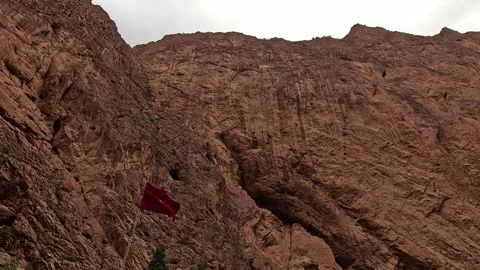 Moroccan flag on a pole against the red cliffs of the Todgha Gorge, Tinghir, 库存影片 344532611