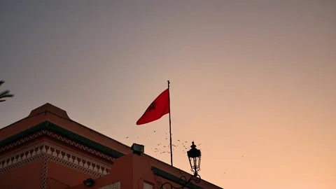Moroccan Flag Waving in Marrakesh at Sunset with Traditional Background Stock Footage 313566035