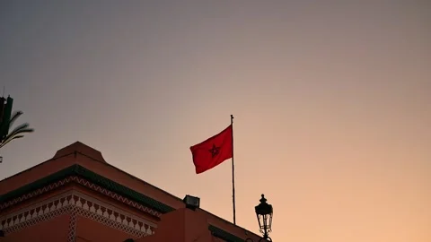 Moroccan Flag Waving in Marrakesh at Sunset with Traditional Background Stock Footage 313566043