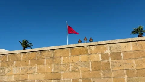 Moroccan flag waving on a tall flagpole against a clear blue sky.  Stock-Footage 332130752